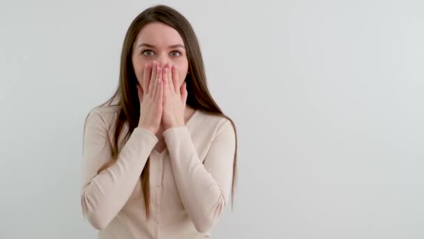 놀라는 여성이 웃으며 가리기 손으로 얼굴을 가리는 감탄한다 스튜디오에서는 행복의 — 비디오