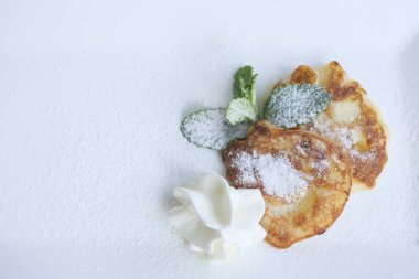 pancakes on white rectangular plate with mint leaves and powdered sugar sprinkled serving dessert Healthy food pancakes with apples berries lunch Grandmas kitchen for children