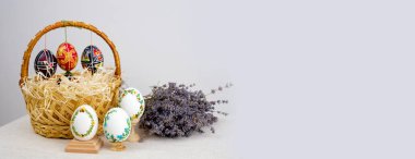 Easter wicker basket with pastel eggs for Happy holiday and celebration on blue background. Banner. Greeting card lavender background postcard baner calendar empty space holiday easter eggs embroidery