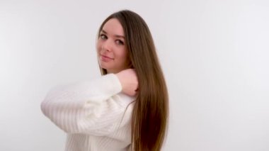 beautiful healthy hair of young cute girl white background studio woman looks into the frame smiling with her back to an empty space For text advertising conditioner shampoo self care self care