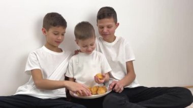 Çocuklar kremalı keklere hevesle bakıyor böyle neşe dolu gülücükler yiyorlar üç ergenlik abisi ve biraz daha az sevinçle pasta yemeye hevesli çocuklar hayranlık duyuyor ve eğleniyorlar.