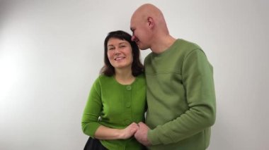 Orta yaşlı bir adam zevkle karısının elini tutarken rahatlamıştır. Kulaklarına hikaye anlatır. Büyüleyici aşklar, beyaz arka planda, aynı yeşil süveterlerle, erkek ve kadın birbirlerine tutunarak flört ederler.