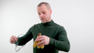 Kafasında üç şımarık muz taşıyan adamın komik fotoğrafı saç stili şaşı gözler şaşı kızıl saçlı, gri sakallı ve bıyıklı yeşil süveterli beyaz arka planda yüz ifadeleri var.
