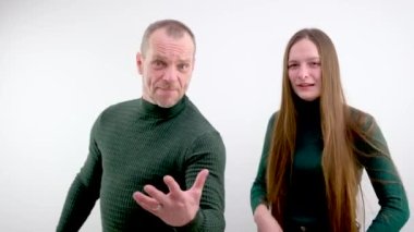 Conflict, quarrel, jealousy in the family home. Young couple, man and woman. The woman is jealous, takes the phone from her husband, demands an explanation. High quality photo