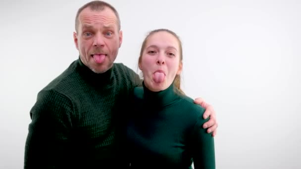 男人和女孩侧身伸出舌头 在背景灯下拍照 父亲和女儿是一名教师 丈夫是一名教师 — 图库视频影像