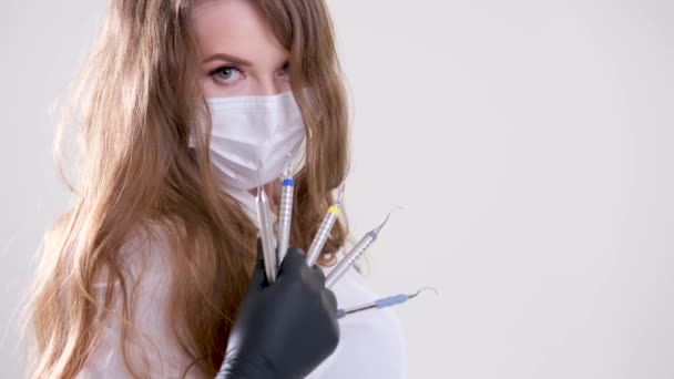 Piękna Kobieta Dentysta Białym Garniturze Białą Maską Płynącymi Włosami Trzyma — Wideo stockowe