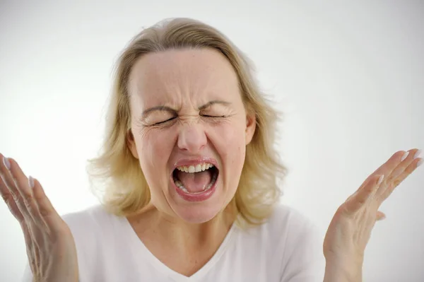 stock image screaming loudly dissatisfied woman sad angry spread arms to sides spread fingers pinched eyes screaming hysteria nerves psychological help nervousness antidepressants studio on white background