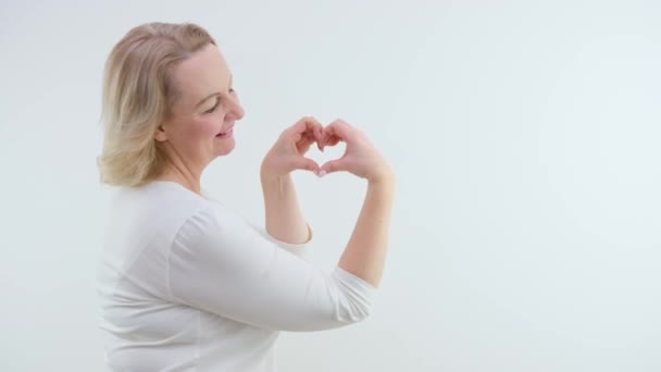 Adult Woman White Sweater Makes Heart Her Hands White Background — Stock Video