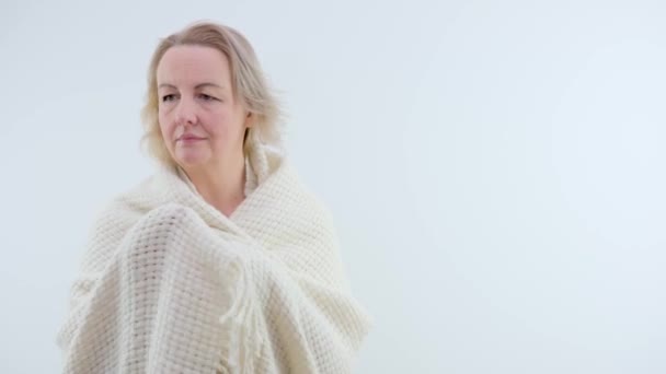 可爱的中年妇女把温暖的羊毛绒格子花披在肩上白色的空间给短信女人直了头发保暖电暖炉冷 — 图库视频影像
