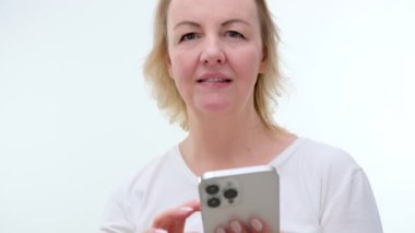 Beyaz telefondaki sayfaları çeviren yakın plan bir kadın orta yaşlı bir kadın parmağını kaldırıyor dikkat çekiyor biri konuşmaya başlıyor telefonu kulağına dayıyor.