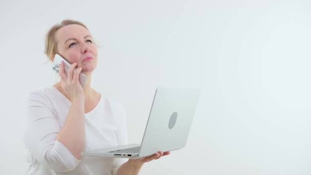 電話で彼女の手の中の女性は彼女が呼び出すときに何を言うか決定します 彼女の目で実行すると思う心配するノートパソコンの優柔不断で見て髪をブロック白い背景期待興奮 — ストック動画