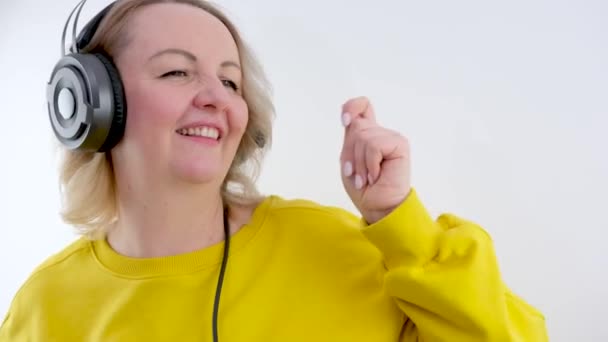 Eine Erwachsene Frau Mit Kopfhörern Tanzt Zur Musik Und Wedelt — Stockvideo
