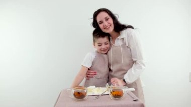 Sabah şefkat anı anne oğluna masanın yanında bir tabak peynirle ve sabah çayıyla sarılıyor aile sevgisiyle geçirilen dinlenme zamanı şefkatle sarılıyor annelik