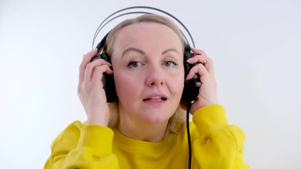Frau Mittleren Alters Setzt Kopfhörer Auf Und Ist Erstaunt Über — Stockvideo