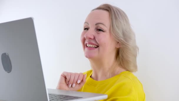 インターネット上で女性がノートパソコンを持ってる顔のレベルで彼女はなぜ笑いが胸に彼女の手を置くか尋ねる楽しい時間を親指を示しています — ストック動画
