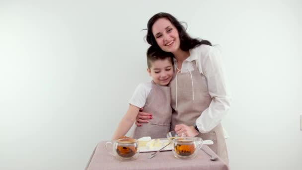 優しさの朝の瞬間チーズプレートと朝のお茶の残りの時間とテーブルの近くに母親抱擁息子家族の愛抱擁優しさの母親の頃 — ストック動画