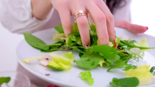Eine Frauenhand Nimmt Einen Salat Und Gießt Ihn Einen Glasteller — Stockvideo