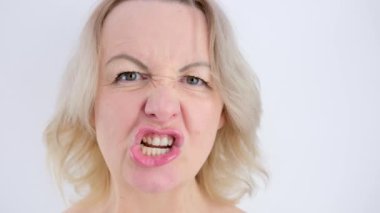 Ağız aşağılayıcı, Yavaş Hareket... kız tatminsiz suratlar yapıyor... dudaklarıyla dişler farklı yönlere hareket ediyor... öfke saldırganlığı yaratıyor... sarışın bir kadının yakın çekim yüzü.