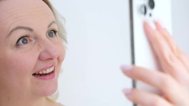Selfie fotoğrafçılığı. Kendini çekerken. Dilini çıkarıp çerçeveli kadına gülerken. Cep telefonuna bakarken.