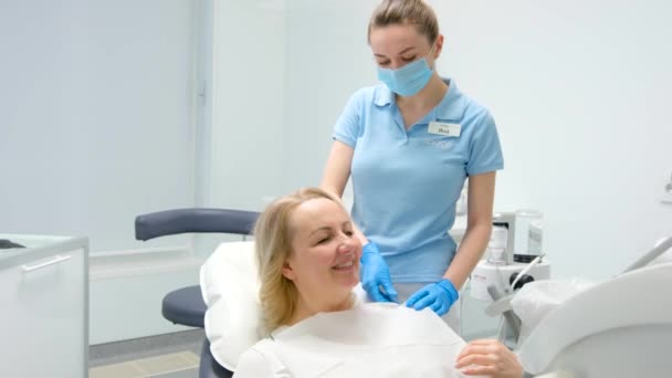 Verpleegkundige Tandheelkundige Kliniek Zet Vrouw Slabbetje Servet Voor Patiënt Tandheelkundige — Stockvideo