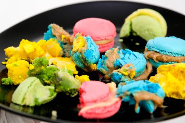 Beyaz arka planda, güzel beyaz bir tabakta bir sürü büyük ısırılmış badem kurabiyesi. İçerik için fotoğraf. Yüksek kalite fotoğraf