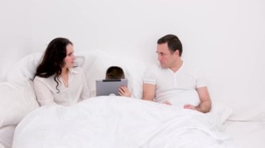 Sosyal Umursamazlık, kocanın tabletle sosyal medyayı izlerken karısının yatakta olması komik. Akıllı telefon suratı ya da Nomofobi sendromu, ilişki kavramı sorunu. Yüksek kalite fotoğraf