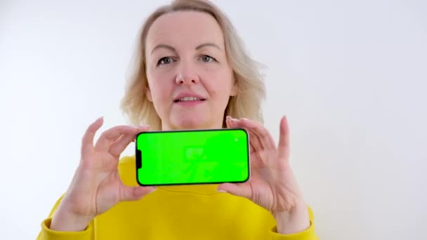 Молодая Счастливая Красивая Блондинка Показывает Телефон Высококачественные Кадры — стоковое видео
