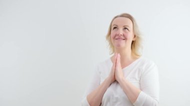 Lütfen, Tanrım yardım et, beni affet. Serbest çalışan bir kadın dua ediyor, yukarı bakıyor ve dilek tutuyor, umut dolu bir ifadeyle soruyor, özür diliyor. Gri stüdyoda izole edilmiş iş kızı.
