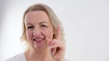 Amerikalı bir kadın yükseltilmiş işaret parmağı gösterir, beyaz bir arka planda dikkat göstergesi. Elini yakın tutan bir kadın. Joy Rıza Reklamı