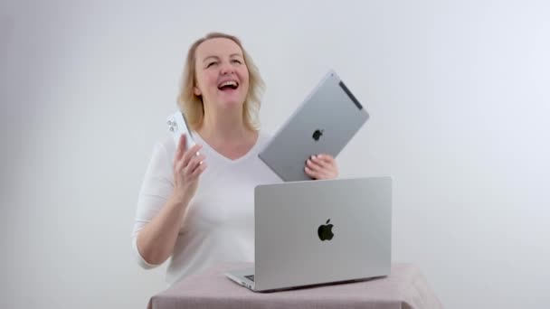 Appleのガジェットを保持している女性彼女はIpadのMacbookと電話を持っています彼Iphone Promax彼女はIpadのタブレットを見て ギフト購入の笑顔販売の広告最新技術ウクライナ2023 — ストック動画