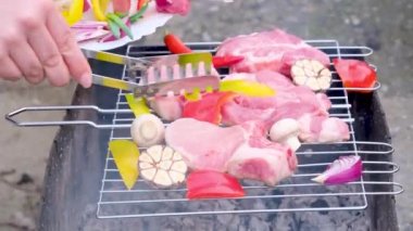 Ahşap arka planda sebzeli çiğ et şişleri. Siyah büyük ızgarada biberli taze çiğ et şiş kebap.