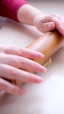 Kadınların elleri mayanın hamurunu sarıp sarmalar. Mutfakta turta pişirmek. Yüksek kaliteli FullHD görüntüler