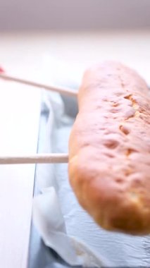 Tahta spatulalar, sıcak elmalı turtayı fırın örtüsünden porselen beyaz kesme tahtasına, masaya servis yapan iki tahta spatulaya, lezzetli kokulu elmalı turtaya aktarır.