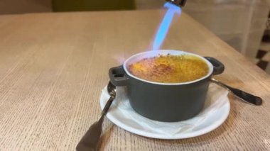 Garson, kremalı krema hazırlamak için gaz ocağı kullanıyor.