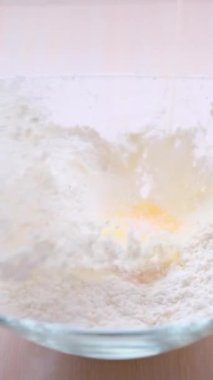 ideal video for advertising cooking show for cooking blog cooking desserts and restaurant eggs falling into flour splashed in slow motion inside flour crumbles on sides white background