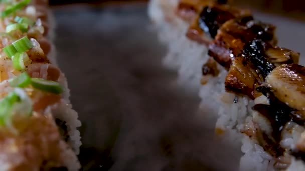 얼음으로 돌판에 참치와 뱀장어를 초밥을 곁들여 식탁에 맛있는 요리는 야자수 — 비디오