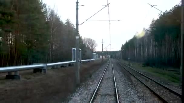 从普热梅斯尔到华沙的火车用左边的煤气管道穿过森林长时间差摄影新的煤气管道运送着来自其他国家的煤气管道秋天的冬天没有雪没有叶子轨道火车开动 — 图库视频影像