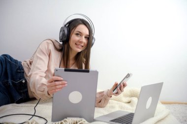 Gülümseyen sekreter telefonlara cevap veriyor ve müşterilerle konuşuyor. Masasında oturuyor ve bir dizüstü bilgisayarla çalışıyor. Yüksek kalite fotoğraf