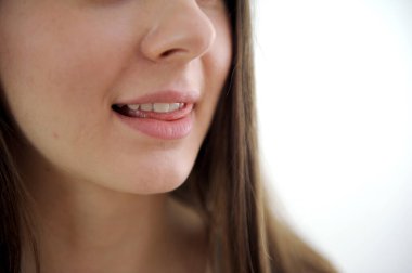 Güzel, neşeli bir kadın, sarışın, sıradan giyinmiş, kameraya tatmin edici bir şekilde bakıyor, mutlu. Güzel bir kadının stüdyo resmi. Boş bir stüdyo duvarında izole edilmiş.