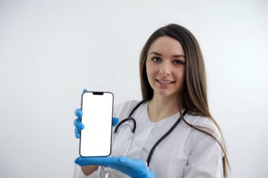 Elinde steteskopu ve telefonu olan tıp doktoru kadının portresi. Beyaz arka planda izole edilmiş. Yüksek kalite fotoğraf