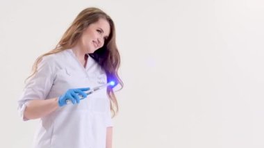 Photopolymer lambası bir kadın doktor lamba gibi bir lamba sihirli bir değnek gibi beyaz arka planda beyaz bir elbise içinde çocuk masalları büyüler