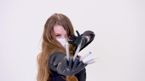 女性の歯医者は忍者のように手には鱗片と切り株を持ってる黒い手袋にマスクをつけてる黒い服を着てる — ストック動画