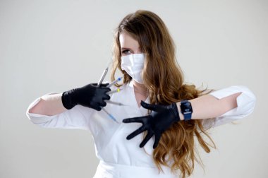 Beautiful woman dentist in black suit with a white mask with flowing hair holds in her hands scaler and curette Hand stretched forward selective focus bright photo of gorgeous woman