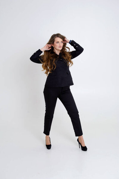 beautiful caucasian blonde woman in black clothes sitting and posing on chair on white. High quality photo