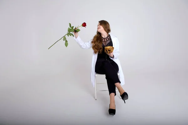 woman sitting on golden white chair smelling a rose Rose falling on the skull of her former lover Lost love murder chic treacherous lady girl on white background high heels european