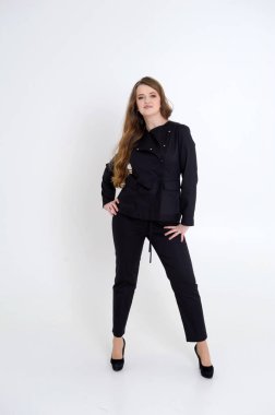 Siyah elbiseli orta yaşlı güçlü bir kadın kameraya ciddi ciddi bakıyor. Parlak gözlü, parlak gözlü, baştan çıkaran bir kadın. Şık patron sıkı öğretmen müfettişi seksi.