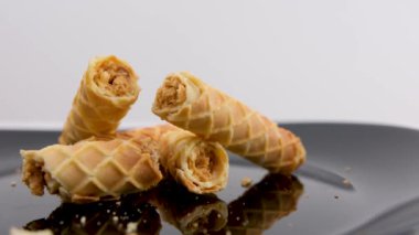 Beyaz arka planda izole edilmiş çikolatalı gevrek çubuğu ya da kakaolu gevrek. Kadın elleri, ev yapımı kurabiye kırma tüpünü kırar ve kahvaltı tatili için cam gibi iki tarafı birbirine vurur.