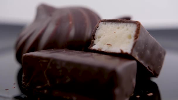 お菓子チョコレートの鳥のミルクと黒プレートの上のチョコレートのマシュマロセクションのキャンディー美しい充填多孔質ソフト食欲をそそるチョコレートパン粉が周りに散在しています — ストック動画
