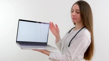 Güzel, genç doktor hemşire elinde beyaz bir ekranla elinde dizüstü bilgisayarla takım toplantısında sunulan ve açıklama için tablet kullanan yeni bir ilaç tedavisinin reklamını yapıyor.