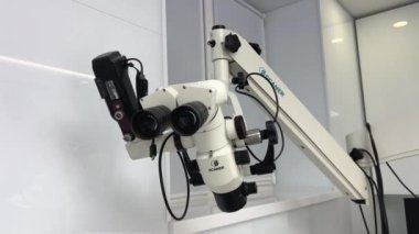 Diş tedavisi için bir diş mikroskobu. Ofisteki Kalipso Ukrayna 2023 adlı doktorlar için çok uygun bir kolye üzerine dişçilik aletlerindeki en son teknoloji.